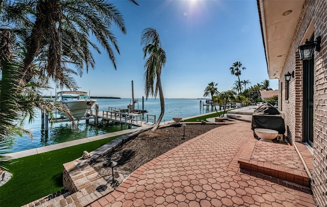 view of patio with a dock, a water view, and boat lift