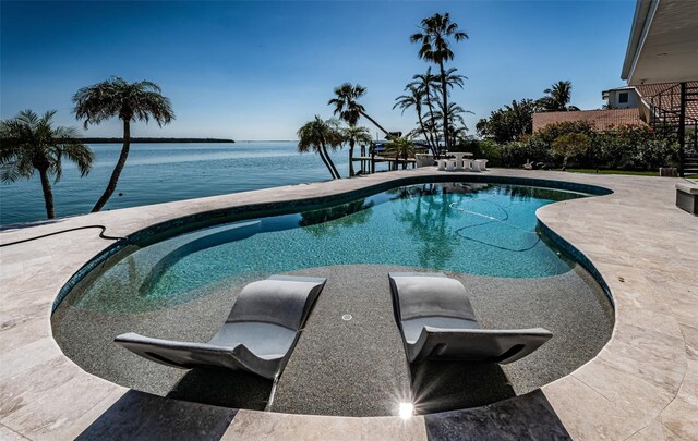 outdoor pool featuring a water view and a patio area