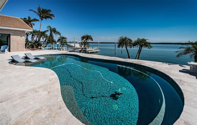 pool featuring a dock, a patio area, and a water view