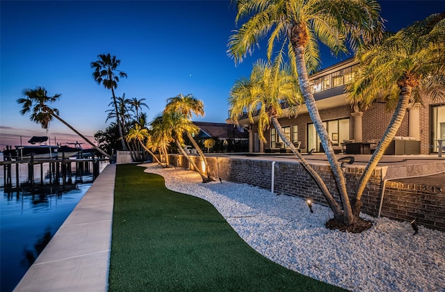 exterior space featuring outdoor lounge area, a lawn, a patio area, and boat lift