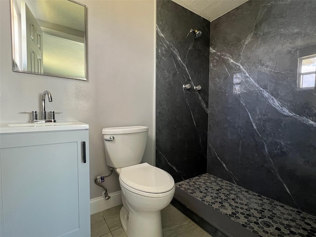 full bath with a marble finish shower, baseboards, toilet, a textured ceiling, and vanity