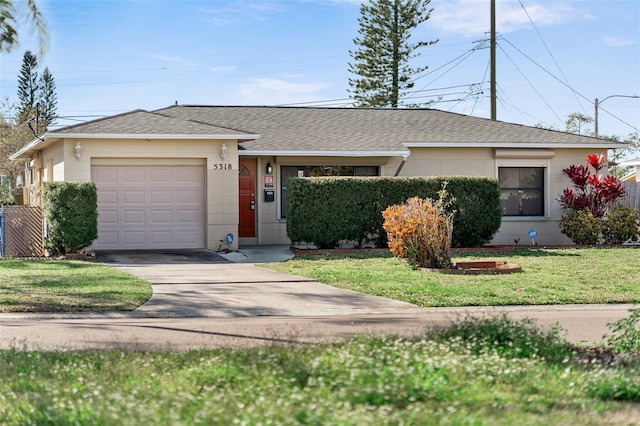 ranch-style home featuring driveway, an attached garage, roof with shingles, and a front yard