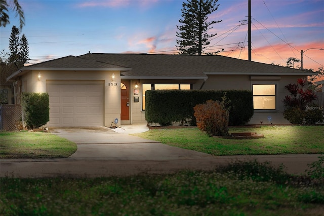 view of front of house featuring an attached garage, a front lawn, and concrete driveway