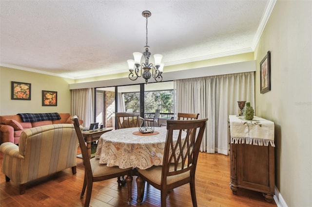 dining room with crown molding, hardwood / wood-style floors, a textured ceiling, a chandelier, and baseboards