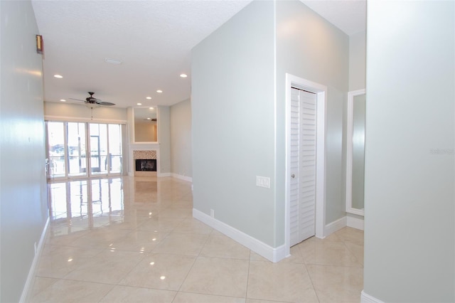 hallway featuring light tile patterned floors, baseboards, and recessed lighting