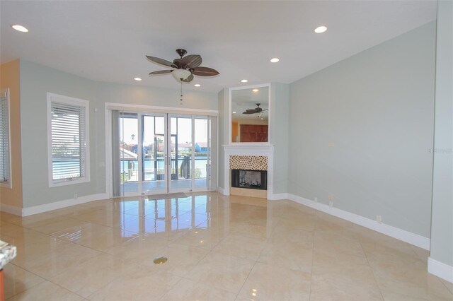 unfurnished living room featuring a fireplace, baseboards, a ceiling fan, and recessed lighting