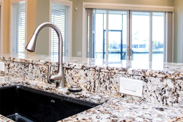 room details featuring a sink and light stone countertops