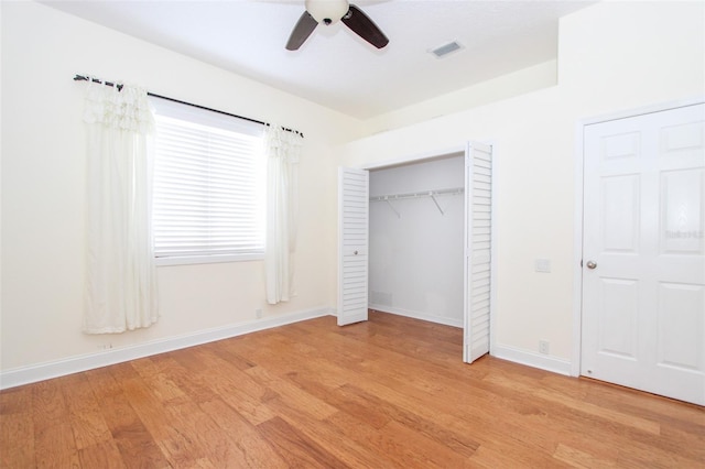 unfurnished bedroom with light wood-style flooring, visible vents, a ceiling fan, baseboards, and a closet