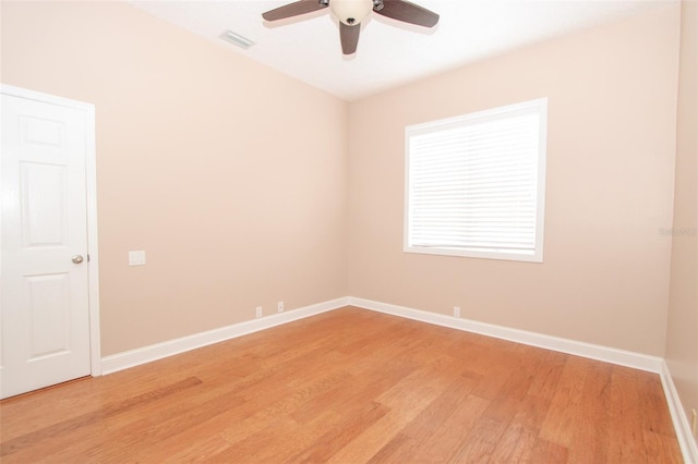 spare room with light wood-type flooring, visible vents, baseboards, and ceiling fan