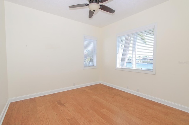 empty room with a ceiling fan, baseboards, and light wood finished floors