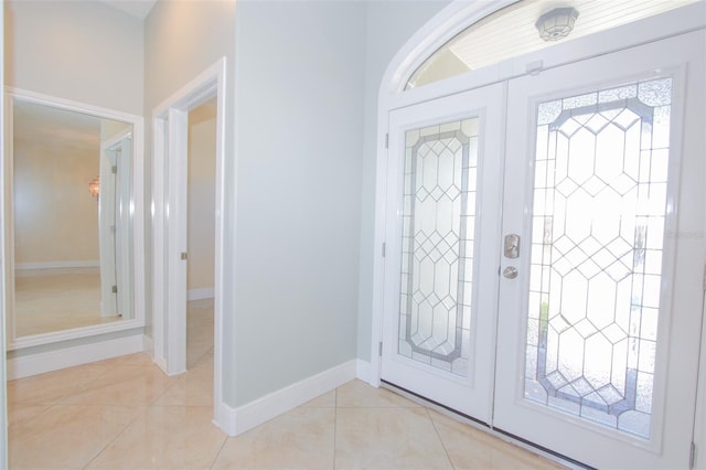 foyer with baseboards, french doors, and light tile patterned flooring