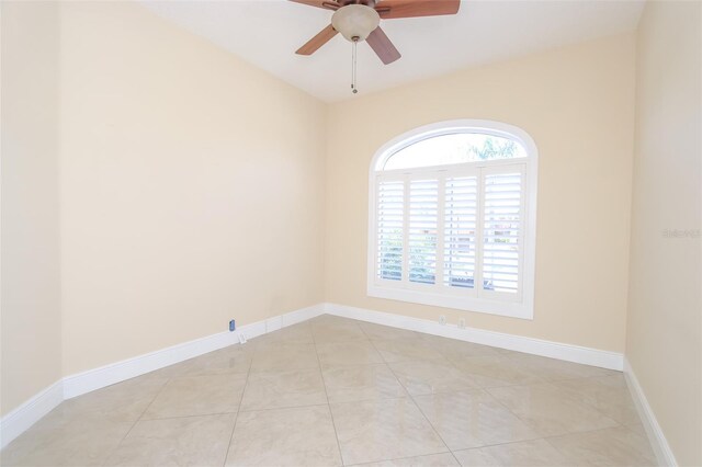 unfurnished room with light tile patterned floors, ceiling fan, and baseboards