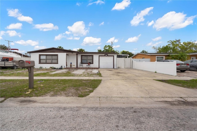 view of front of home with an attached garage, fence, concrete driveway, and stucco siding