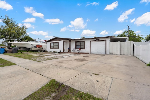 view of front facade with driveway, an attached garage, fence, and stucco siding