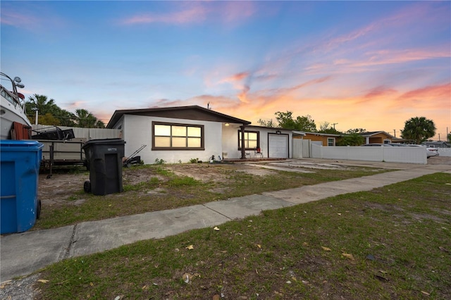 view of front of home featuring an attached garage and fence