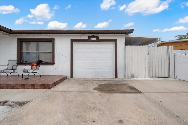 garage featuring driveway and fence