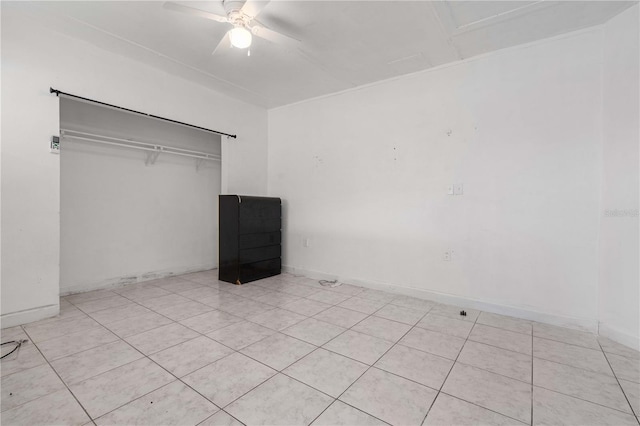 unfurnished bedroom with ceiling fan, baseboards, and a closet