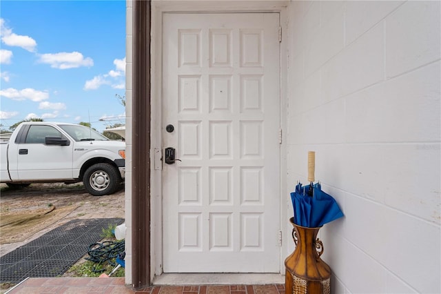 doorway to property featuring concrete block siding