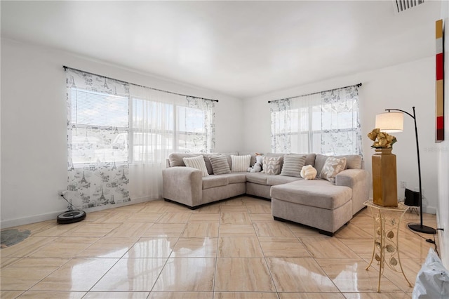 living room featuring visible vents, a wealth of natural light, and baseboards