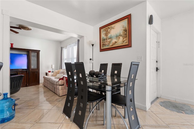 dining room with a ceiling fan and baseboards