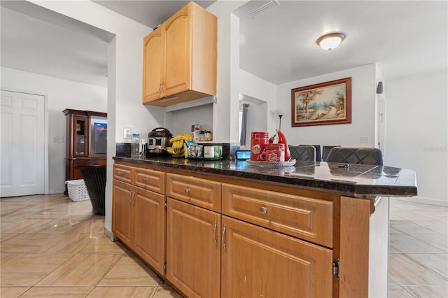 kitchen with visible vents, a peninsula, and baseboards