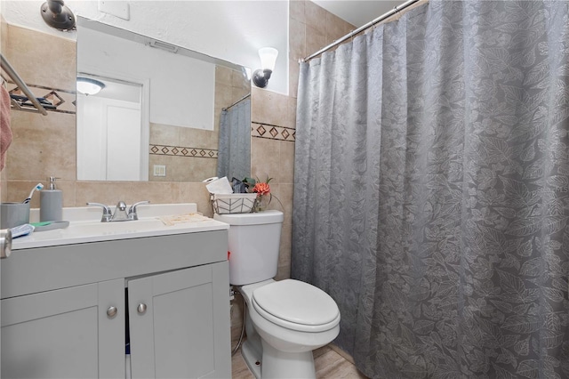 bathroom featuring toilet, curtained shower, tile walls, and vanity