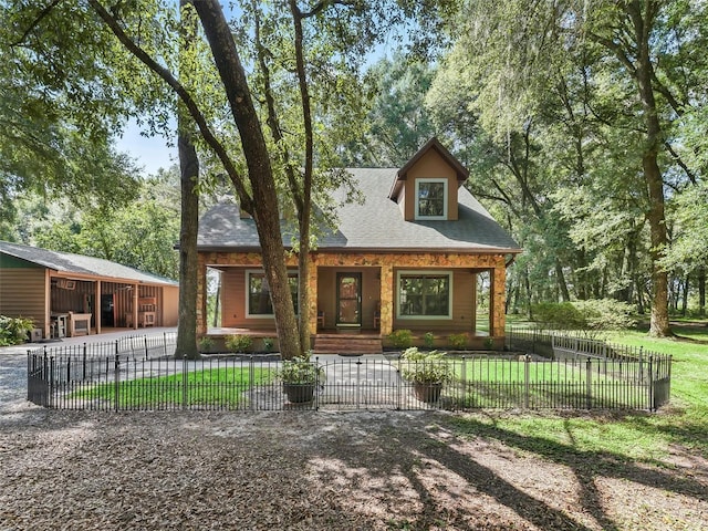 view of front facade featuring a shingled roof, a fenced front yard, and a front yard