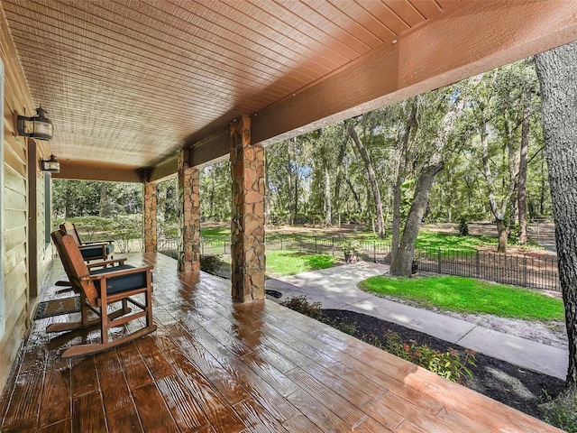 wooden terrace featuring a porch and fence