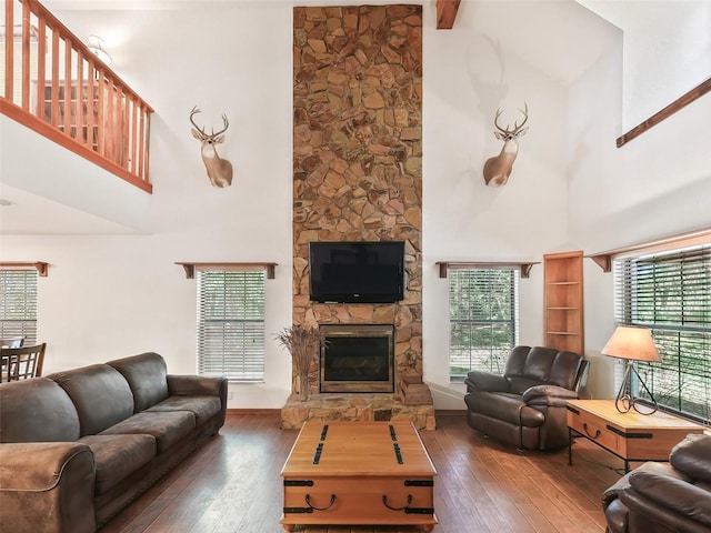 living room featuring a stone fireplace, hardwood / wood-style floors, and a wealth of natural light