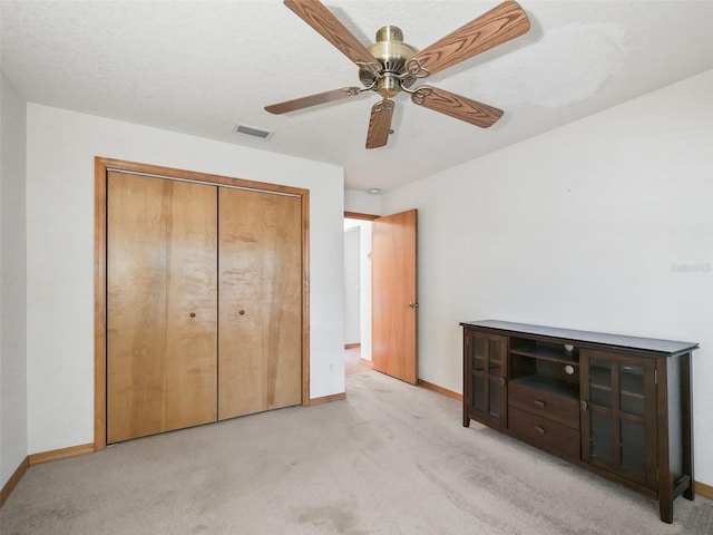 unfurnished bedroom with baseboards, visible vents, a closet, and light colored carpet