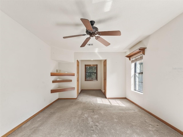 empty room featuring light carpet, baseboards, visible vents, and a ceiling fan