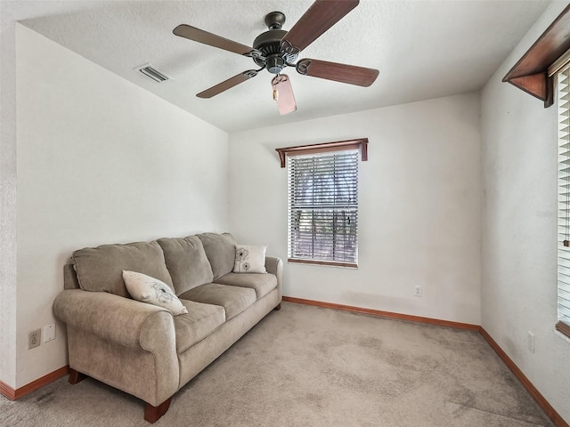 living room featuring baseboards, visible vents, and light colored carpet