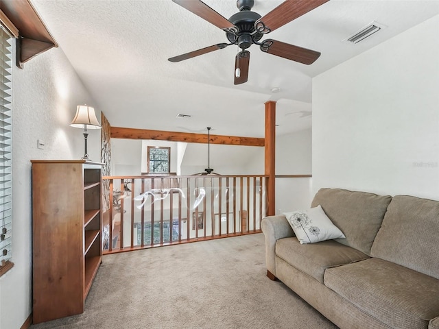 sitting room with a textured ceiling, visible vents, vaulted ceiling, and carpet flooring