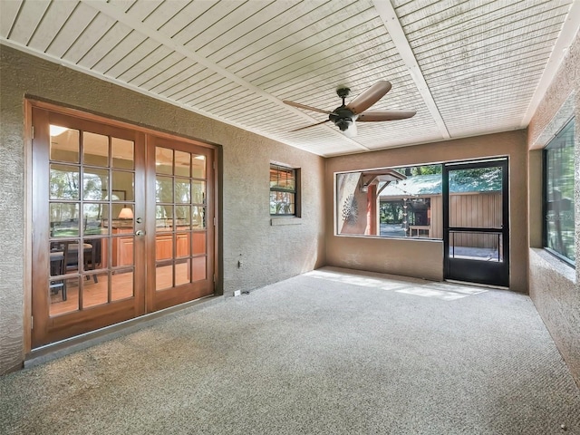 unfurnished sunroom with a ceiling fan, french doors, and wooden ceiling