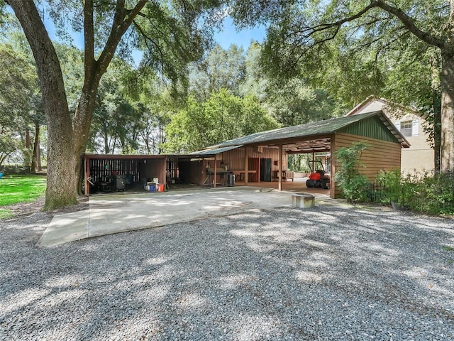 view of front of house featuring a carport, an outbuilding, and gravel driveway