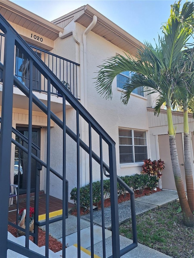 view of side of property featuring stairs and stucco siding