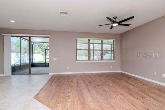 empty room featuring wood finished floors, baseboards, visible vents, recessed lighting, and ceiling fan