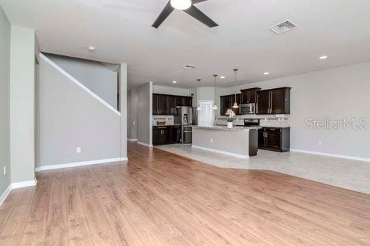 unfurnished living room with visible vents, baseboards, ceiling fan, recessed lighting, and light wood-style flooring