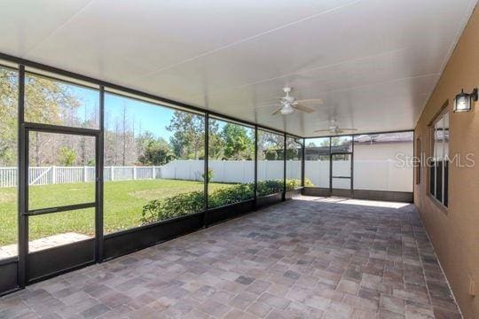 unfurnished sunroom with a ceiling fan