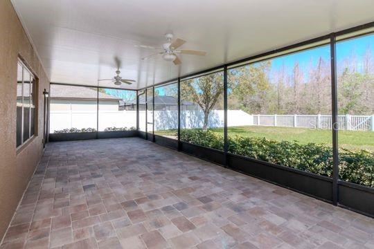 unfurnished sunroom featuring a ceiling fan