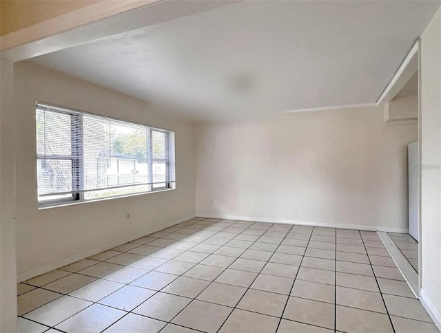 empty room featuring light tile patterned floors and baseboards