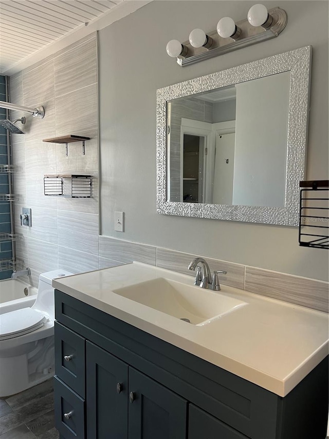 bathroom featuring toilet, shower / bathtub combination, tile walls, and vanity