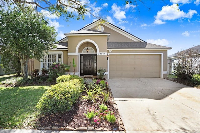 view of front of property with stucco siding, driveway, and an attached garage