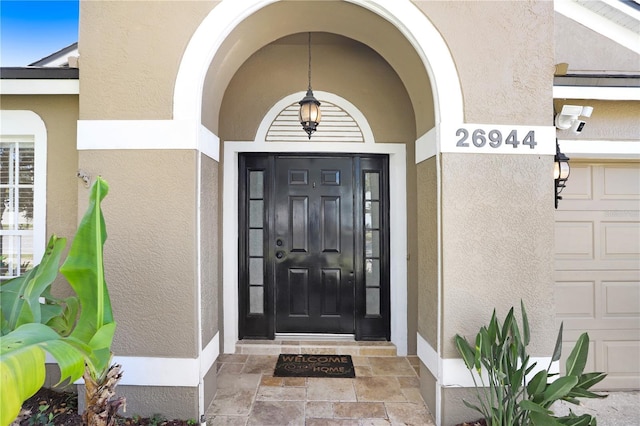 doorway to property featuring stucco siding