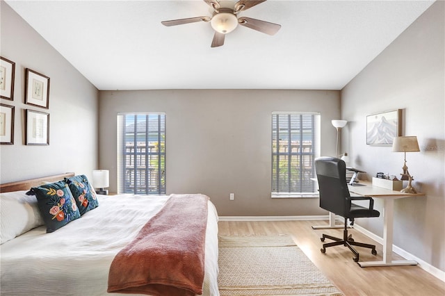 bedroom featuring light wood-style flooring, a ceiling fan, and baseboards