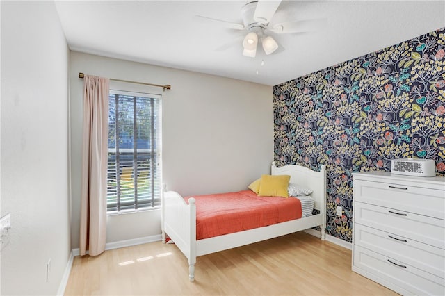 bedroom featuring multiple windows, light wood-style flooring, and baseboards