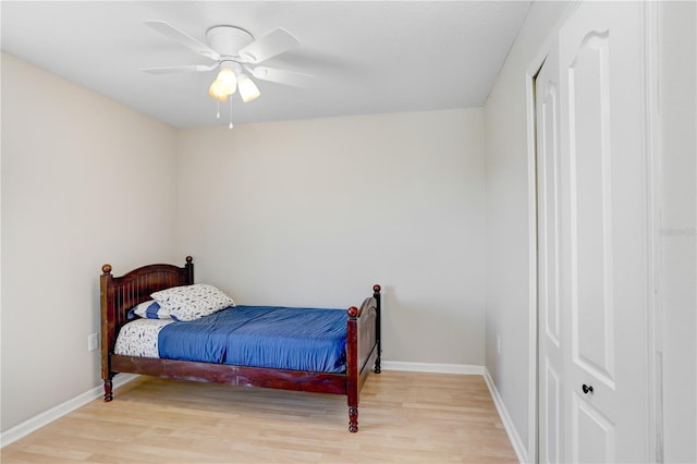 bedroom featuring baseboards, a ceiling fan, and light wood finished floors