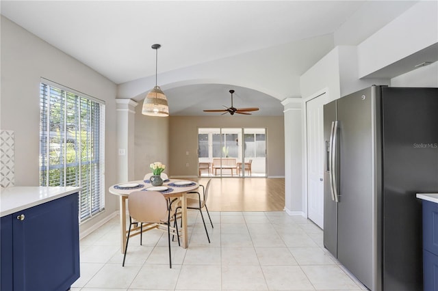 dining space with ceiling fan, baseboards, light tile patterned floors, arched walkways, and ornate columns