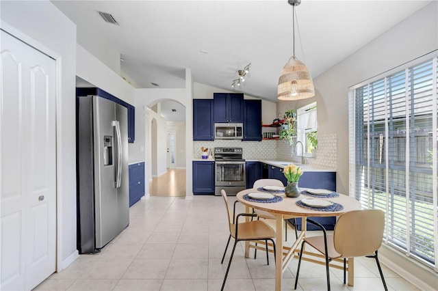 dining space featuring light tile patterned flooring, arched walkways, visible vents, and plenty of natural light