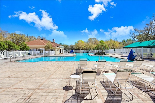 community pool featuring a patio area and fence